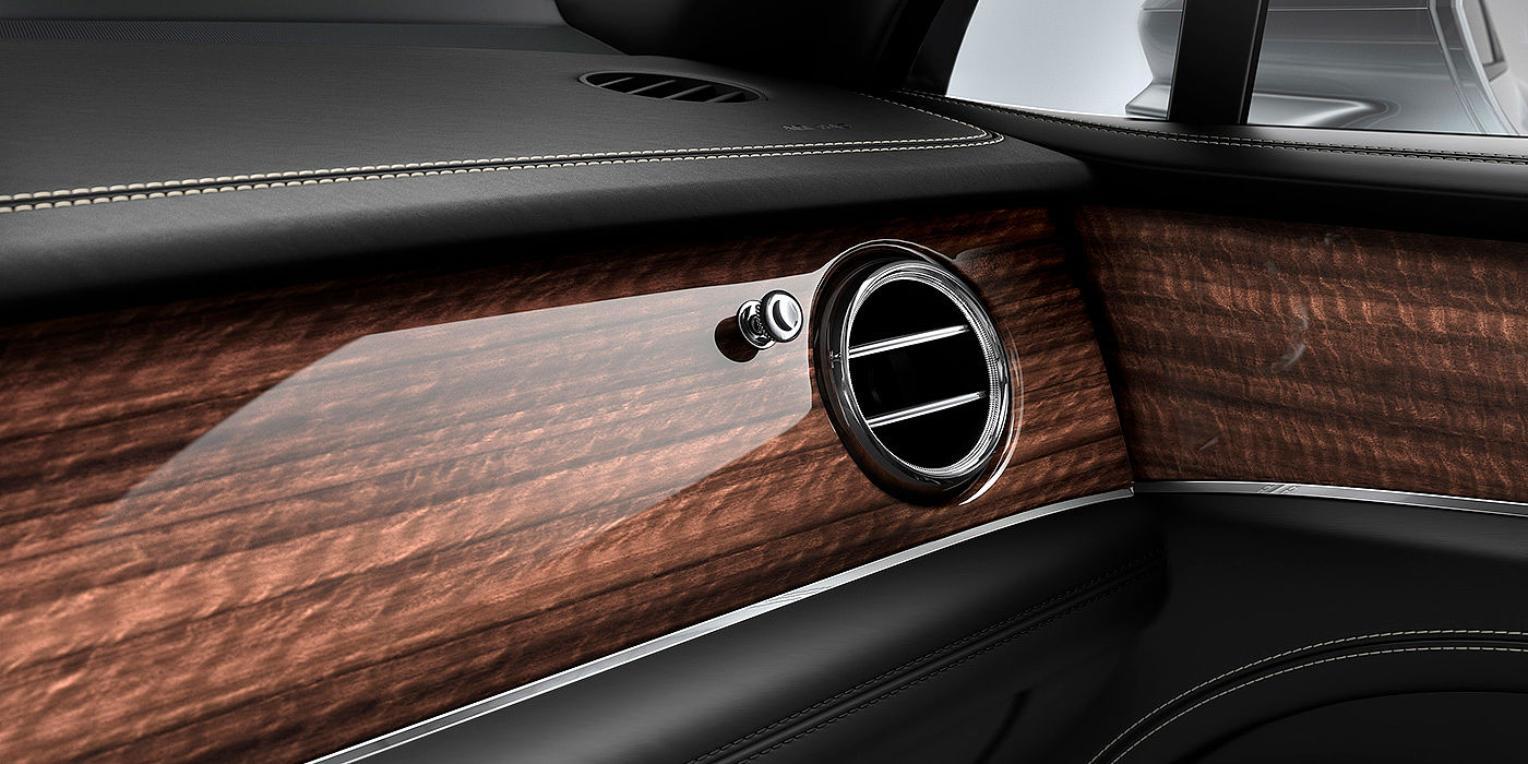 Bentley Praha Bentley Bentayga front interior Crown Cut Walnut veneer and chrome air vent.