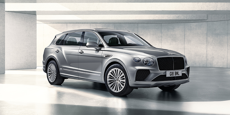 Bentley Praha Bentley Bentayga Extended Wheelbase SUV front three quarter in Moonbeam paint with a grey background